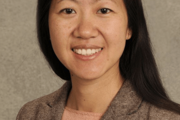 Photo of Wendy Pierce wearing a dark tan sweater on a light tan background