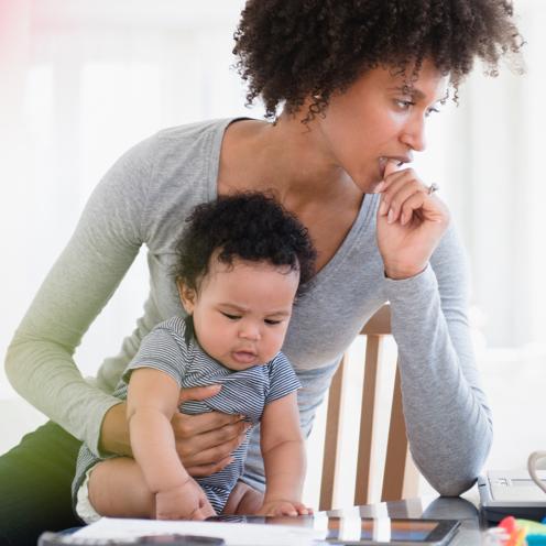 Mother holding her baby at a table