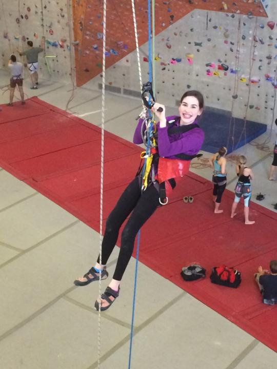 Young woman participating in adaptive rock climbing