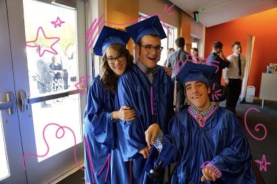 Photo of a young woman and two young men wearing blue graduation caps and gowns.