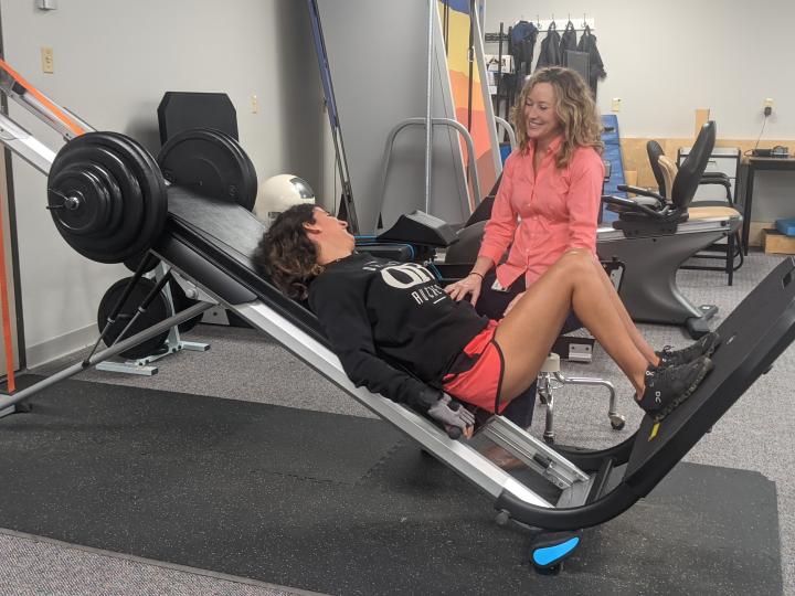 LSU Landing page with girl on a leg press machine next to researcher