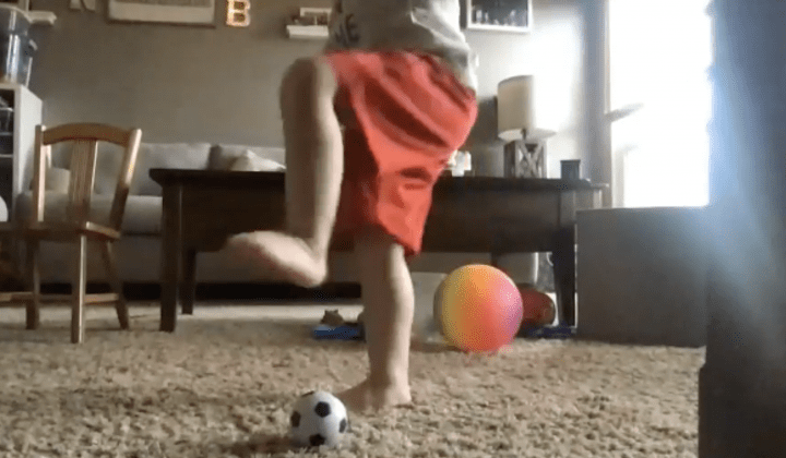 A child Kicking an orange ball