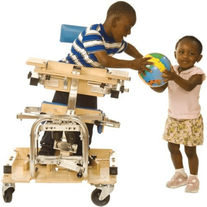 Boy wearing a blue shirt in a stander handing a ball to a little girl in a pink dress