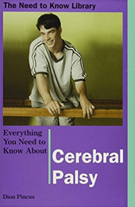 Boy in gray shirt smiling and leaning on a wooden rail