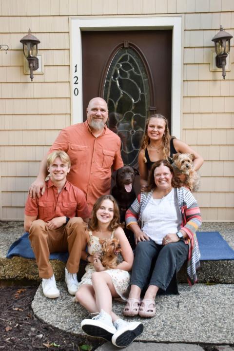 Stacy Mcneely with her husband and three young adult children and their adorable dogs.