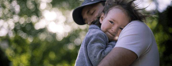 Father hugging his child outdoors.