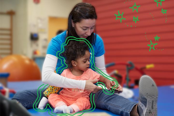 Briana (Age 4) in therapy moving a puzzle piece with her PT