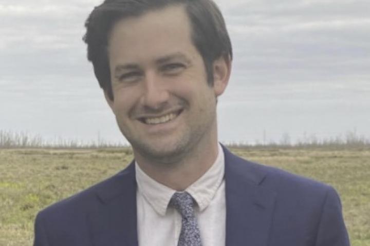 Photo of Noam Platt wearing a blue sport coat and tie.