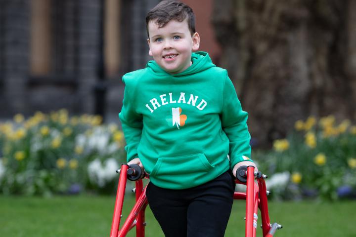 Image of a young boy with dark hair and wearing a green sweatshirt that says Ireland on it..