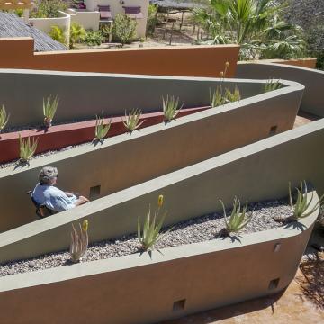 A ramp that has two turns and is part of the outdoor landscaping of a home