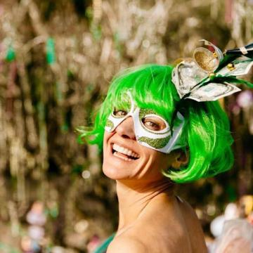 Photo of Jen Lyman in a green wig and and a mardi gras mask
