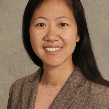 Photo of Wendy Pierce wearing a dark tan sweater on a light tan background