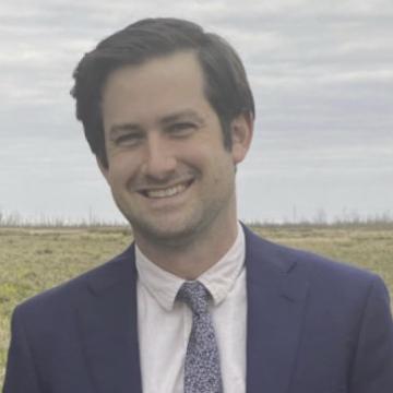 Photo of Noam Platt wearing a blue sport coat and tie.