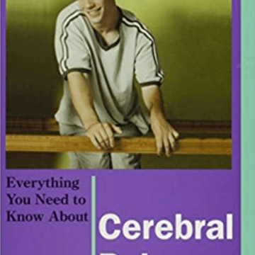 Boy in gray shirt smiling and leaning on a wooden rail