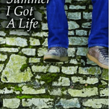 Boy in blue jeans and gray sneakers dangling his legs over a brick wall
