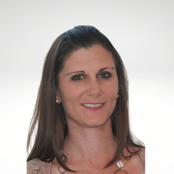 Lorene has long brown hair and is smiling. She is wearing a tan top.