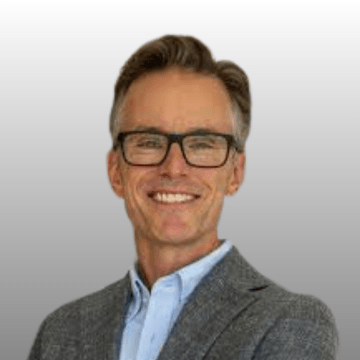 Headshot of Dr. Adam Kirton wearing black framed glasses.