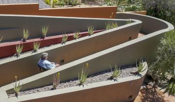 A ramp that has two turns and is part of the outdoor landscaping of a home