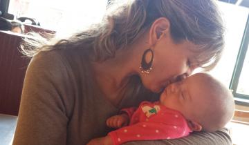 Sarah holding Taryn and kissing her on the cheek.
