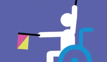 Child in wheelchair raising flags