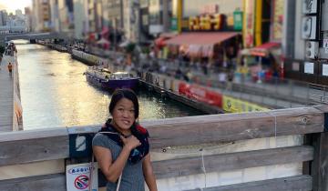 "A Trip Down the Memory Lane of Travel: Part Three" written in text above an image of writer, Sarah Kim, in front of a river in Japan