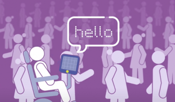 Representation of a person in a wheelchair using assistive technology to communicate with a group of people around them.