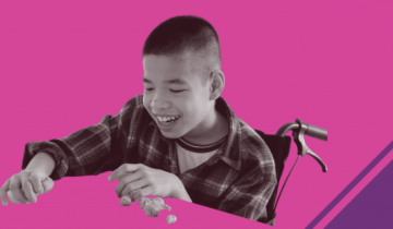Asian boy in wheelchair playing with clay on a pink and purple background