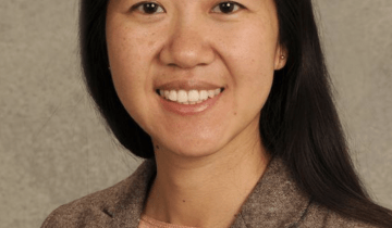 Photo of Wendy Pierce wearing a dark tan sweater on a light tan background