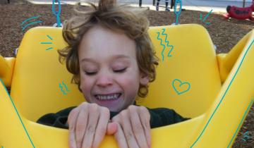 Smiling boy in yellow adaptive swing