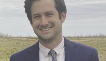 Photo of Noam Platt wearing a blue sport coat and tie.