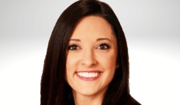 Danielle Lemke has long dark brown hair and is smiling. She is wearing a black blazer.
