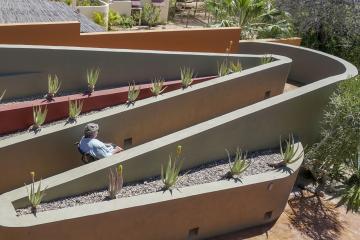 A ramp that has two turns and is part of the outdoor landscaping of a home