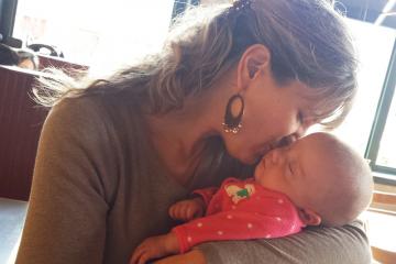 Sarah holding Taryn and kissing her on the cheek.