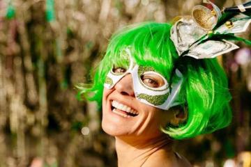 Photo of Jen Lyman in a green wig and and a mardi gras mask