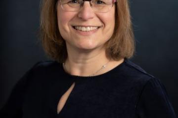 Photo of Amy Bailes in a black shirt on a black background