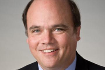 Photo of Dr. Hank Chambers wearing a black sport jacket and tie.