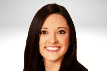 Danielle Lemke has long dark brown hair and is smiling. She is wearing a black blazer.