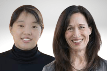 Debbie Song has dark hair pulled back and is wearing a black turtle neck. She is standing next to Marie Ward who has long dark hair and is wearing a grey blazer over a black shirt.